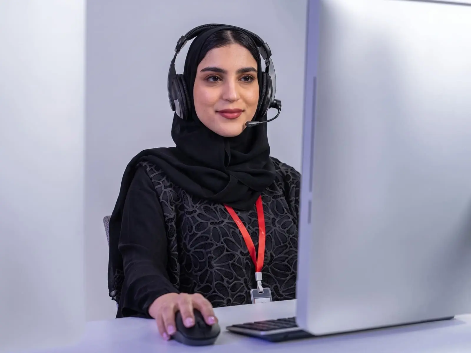 A customer service agent wearing a headset at her desk